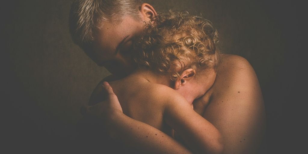 topless person carrying children