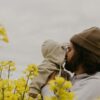 a man and woman kissing in a field of yellow flowers